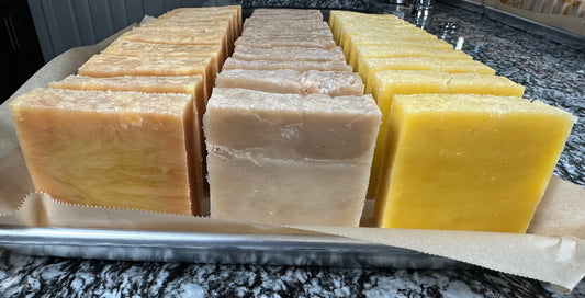 Tray showing three loaves of handmade soap individually sliced into bars.
