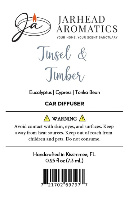 Product label for a Jarhead Aromatics Tinsel & Timber Car Diffuser, listing notes of eucalyptus, cypress, and tonka bean, alongside safety warnings, origin, volume, and a barcode.