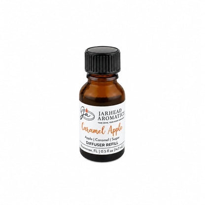 A small amber glass bottle labeled “Jarhead Aromatics Caramel Apple Cold Air Diffuser Refill | Crisp Apple, Rich Caramel & Warm Spice” with a black screw cap, placed on a white background. This home fragrance oil by Jarhead Aromatics is perfect for your cold air diffuser, filling your space with the warm and inviting scent of crisp apple, rich caramel, and warm spice.