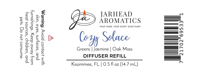 Jarhead Aromatics Cozy Solace Cold Air Diffuser Refill features a clean white label with black, blue, and gold text. The 0.5 fl oz home fragrance oil is crafted in Kissimmee, FL, and displays warnings and scent notes of fresh greens, jasmine, and oak moss for an autumn forest-inspired aroma.