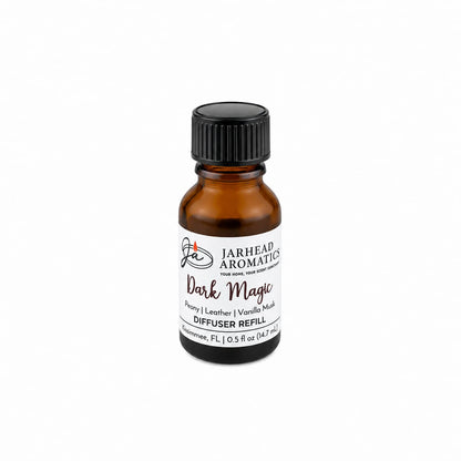 A small amber glass bottle labeled Jarhead Aromatics Dark Magic Cold Air Diffuser Refill, featuring notes of peach, plum, dark florals, and vanilla musk, evokes the allure of gothic romance. Suitable as a home fragrance oil or cold air diffuser refill, it is displayed on a white background.