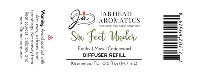 White label for Jarhead Aromatics Six Feet Under Cold Air Diffuser Refill | Damp Earth, Moss & Ancient Oak. This earthy home fragrance combines notes of damp earth, moss, and ancient oak to create the perfect Halloween scent for any space. Includes warning text, barcode, and product size: 0.5 fl oz (14.7 mL).