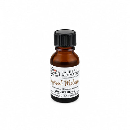 A small amber glass bottle labeled Jarhead Aromatics Sugared Molasses Cold Air Diffuser Refill | Buttercream, Honey & Dark Molasses, featuring a black screw cap. The label highlights notes of beeswax, honey, and molasses and indicates 0.5 fl oz (14.7 ml). This delightful home fragrance oil offers a rich gourmand scent that’s perfect for enhancing any space.