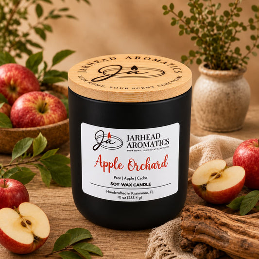 A black Apple Orchard Soy Wax Candle | Pear, Apple & Cedar in a jar with a wooden lid, surrounded by fresh apples, apple slices, and cedar wood pieces on a wooden surface.