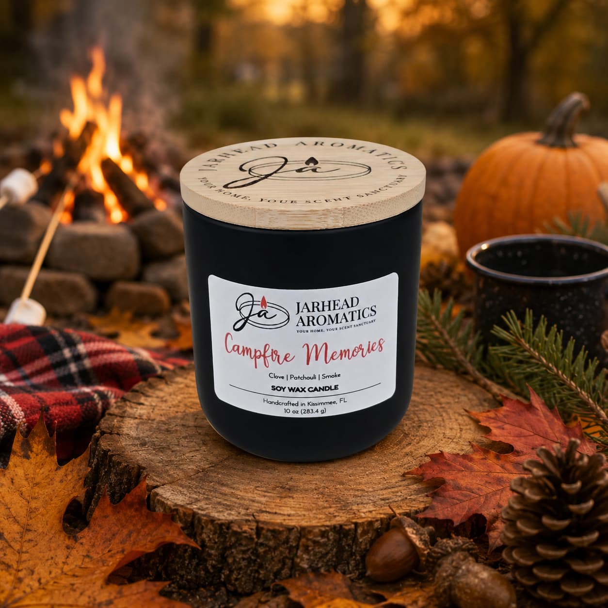 A Jarhead Aromatics Campfire Memories Soy Wax Candle—with smoky embers, maple, moss, and patchouli notes—rests on a log near autumn leaves. In the background, a campfire flickers beside a mug, pinecone, and cozy blanket, evoking a warm and rustic outdoor setting. This fall candle fills the air with nostalgic fragrances reminiscent of evenings spent by the fire.