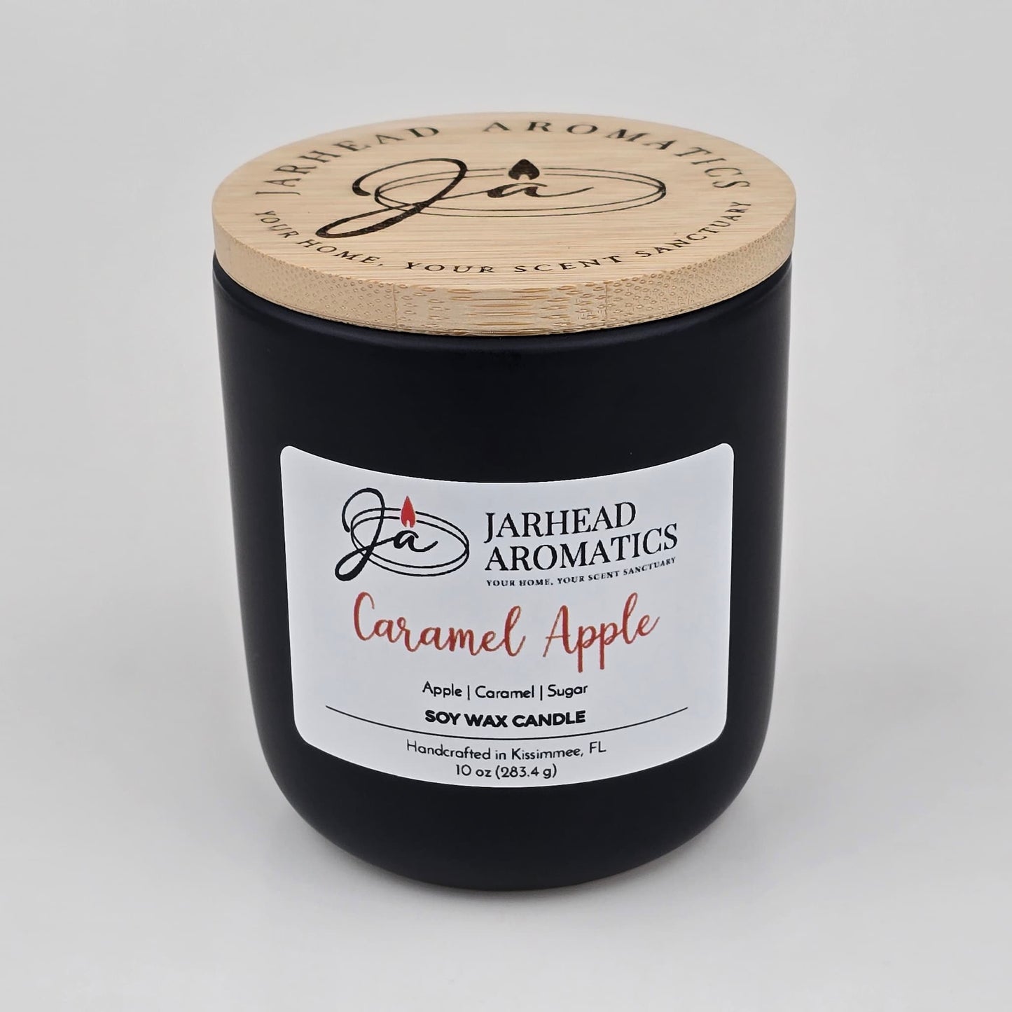 Experience the luscious gourmand fragrance of apple, caramel, and sugar with the Caramel Apple Soy Wax Candle by Jarhead Aromatics. This handcrafted 10 oz black jar candle features a wooden lid and is labeled with “Jarhead Aromatics Caramel Apple.” Made in Kissimmee, FL from soy wax, it fills your space with the inviting scents of apple cider, caramel, and sugar.