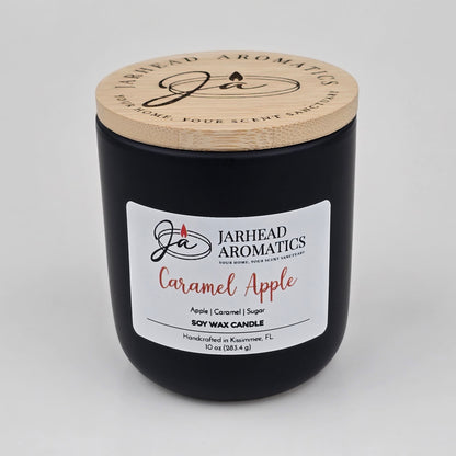 Experience the luscious gourmand fragrance of apple, caramel, and sugar with the Caramel Apple Soy Wax Candle by Jarhead Aromatics. This handcrafted 10 oz black jar candle features a wooden lid and is labeled with “Jarhead Aromatics Caramel Apple.” Made in Kissimmee, FL from soy wax, it fills your space with the inviting scents of apple cider, caramel, and sugar.