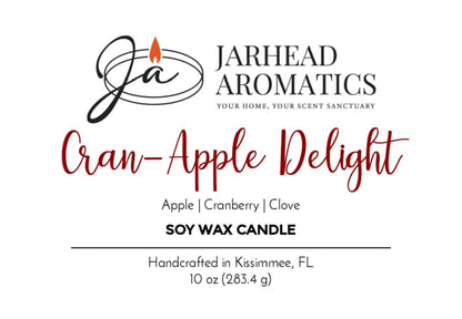 Jarhead Aromatics label for Cran-Apple Delight Soy Wax Candle | Cranberry, Apple & Cinnamon Candle. Scent notes: cranberry, apple, and cinnamon. Handcrafted in Kissimmee, FL. White background with black and red text, featuring a candle flame logo. Enjoy the warm aroma of our Cran-Apple Delight Soy Wax Candle with every burn.