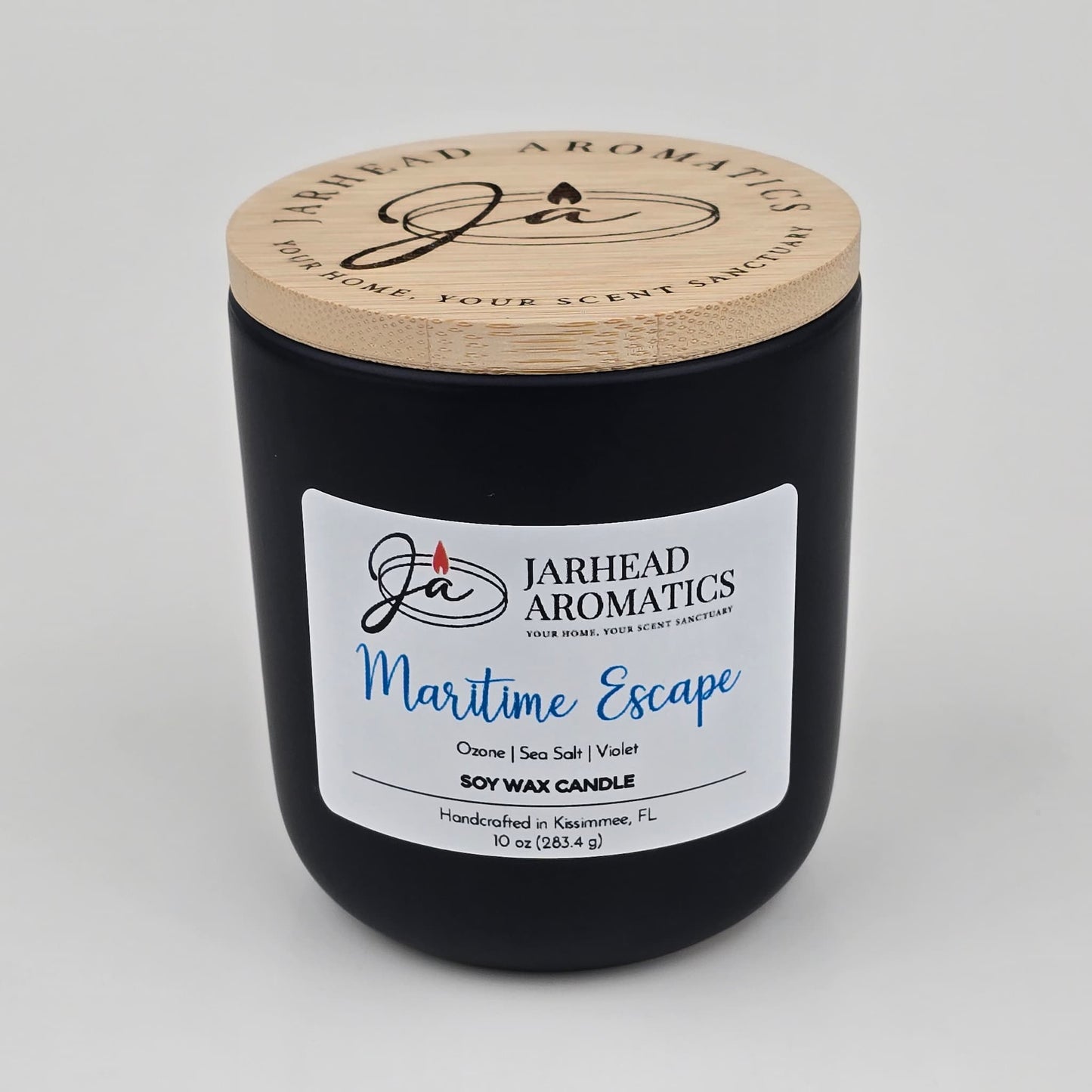 Introducing the Maritime Escape Soy Wax Candle by Jarhead Aromatics, a coastal-inspired candle handcrafted in Kissimmee, FL. Housed in a sleek black jar with a wooden lid and signature branding, this 10 oz soy candle blends invigorating notes of sea salt, ozone, and cedar for an ocean-fresh fragrance experience.