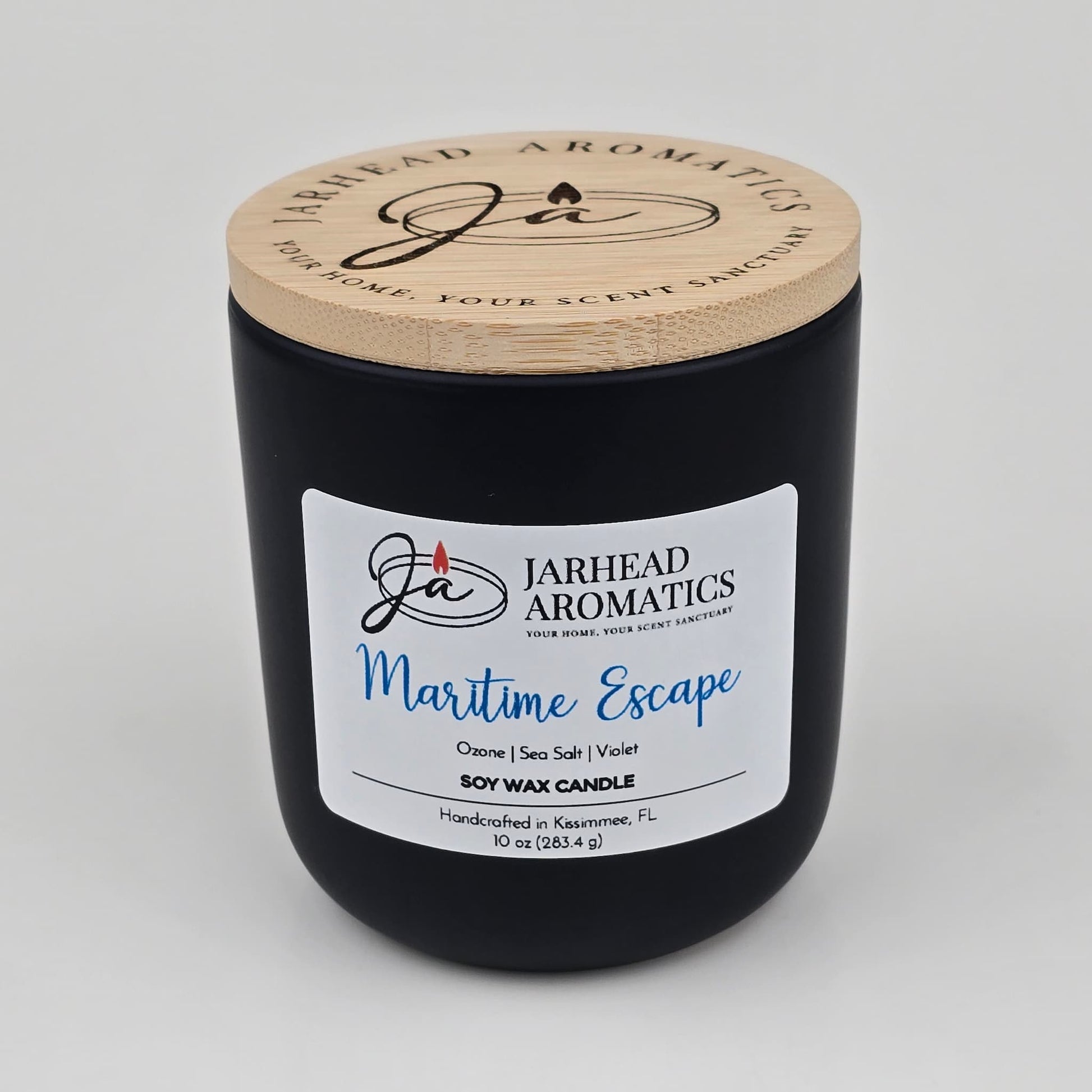 Introducing the Maritime Escape Soy Wax Candle by Jarhead Aromatics, a coastal-inspired candle handcrafted in Kissimmee, FL. Housed in a sleek black jar with a wooden lid and signature branding, this 10 oz soy candle blends invigorating notes of sea salt, ozone, and cedar for an ocean-fresh fragrance experience.