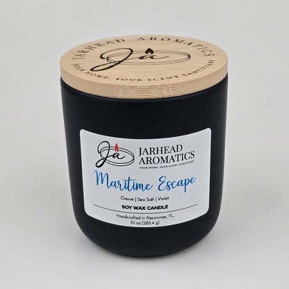Introducing the Maritime Escape Soy Wax Candle by Jarhead Aromatics, a coastal-inspired candle handcrafted in Kissimmee, FL. Housed in a sleek black jar with a wooden lid and signature branding, this 10 oz soy candle blends invigorating notes of sea salt, ozone, and cedar for an ocean-fresh fragrance experience.