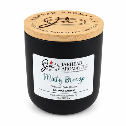 A black Jarhead Aromatics Minty Breeze Soy Wax Candle with a bamboo lid and a white label featuring the text Minty Breeze, Peppermint, Cedar & Powder.
