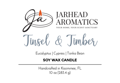 Jarhead Aromatics Tinsel & Timber Soy Wax Candle from the Winter Collection features eucalyptus, cypress, and tonka bean scents. Handcrafted in Kissimmee, FL. 10 oz (283.4 g). Label shows brand logo with a lit candle.