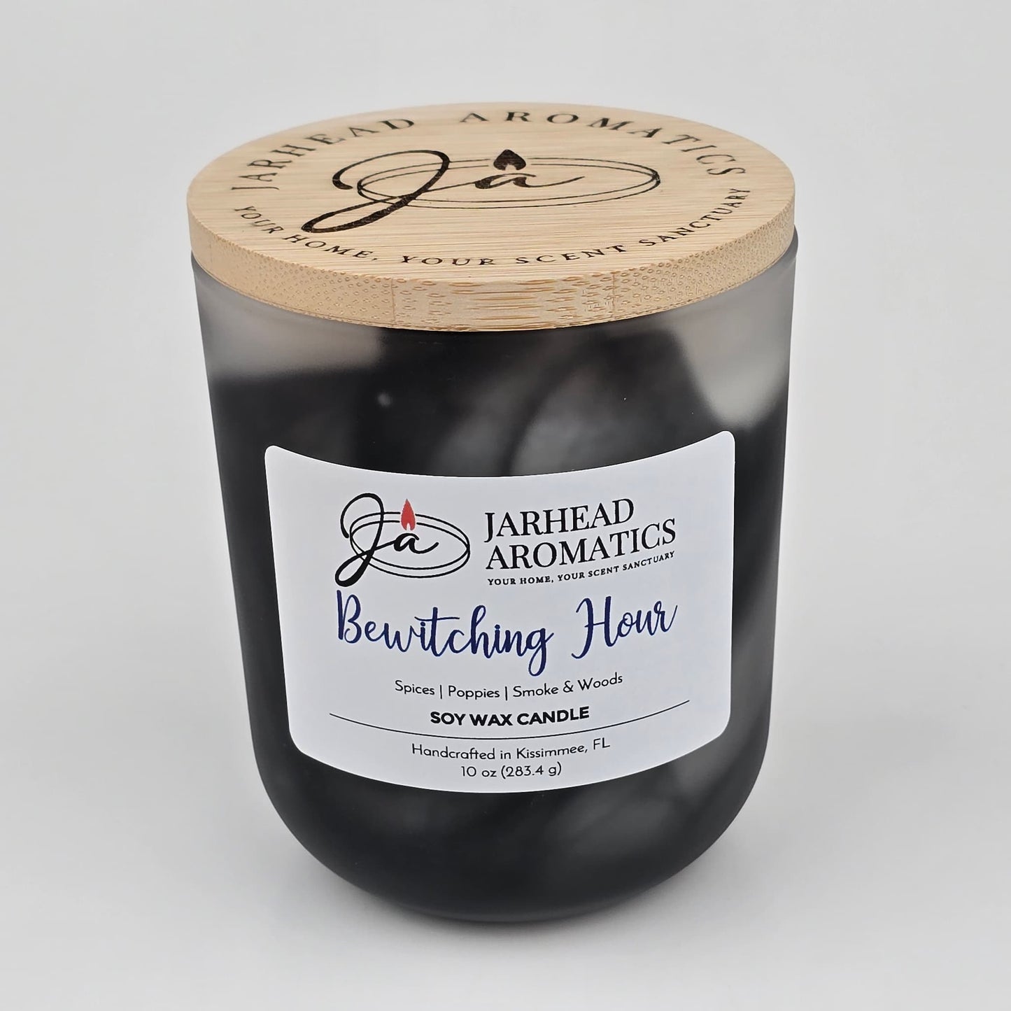 A handcrafted black jar candle from Jarhead Aromatics, the Bewitching Hour Soy Wax Candle features a wooden lid and a striking label. Infused with notes of spiced poppy, smoky woods, and dark florals, this candle captures an enchanting Halloween fragrance—perfect for creating a moody seasonal ambiance. Made with soy wax in Kissimmee, FL.