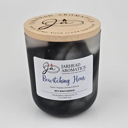 A handcrafted black jar candle from Jarhead Aromatics, the Bewitching Hour Soy Wax Candle features a wooden lid and a striking label. Infused with notes of spiced poppy, smoky woods, and dark florals, this candle captures an enchanting Halloween fragrance—perfect for creating a moody seasonal ambiance. Made with soy wax in Kissimmee, FL.