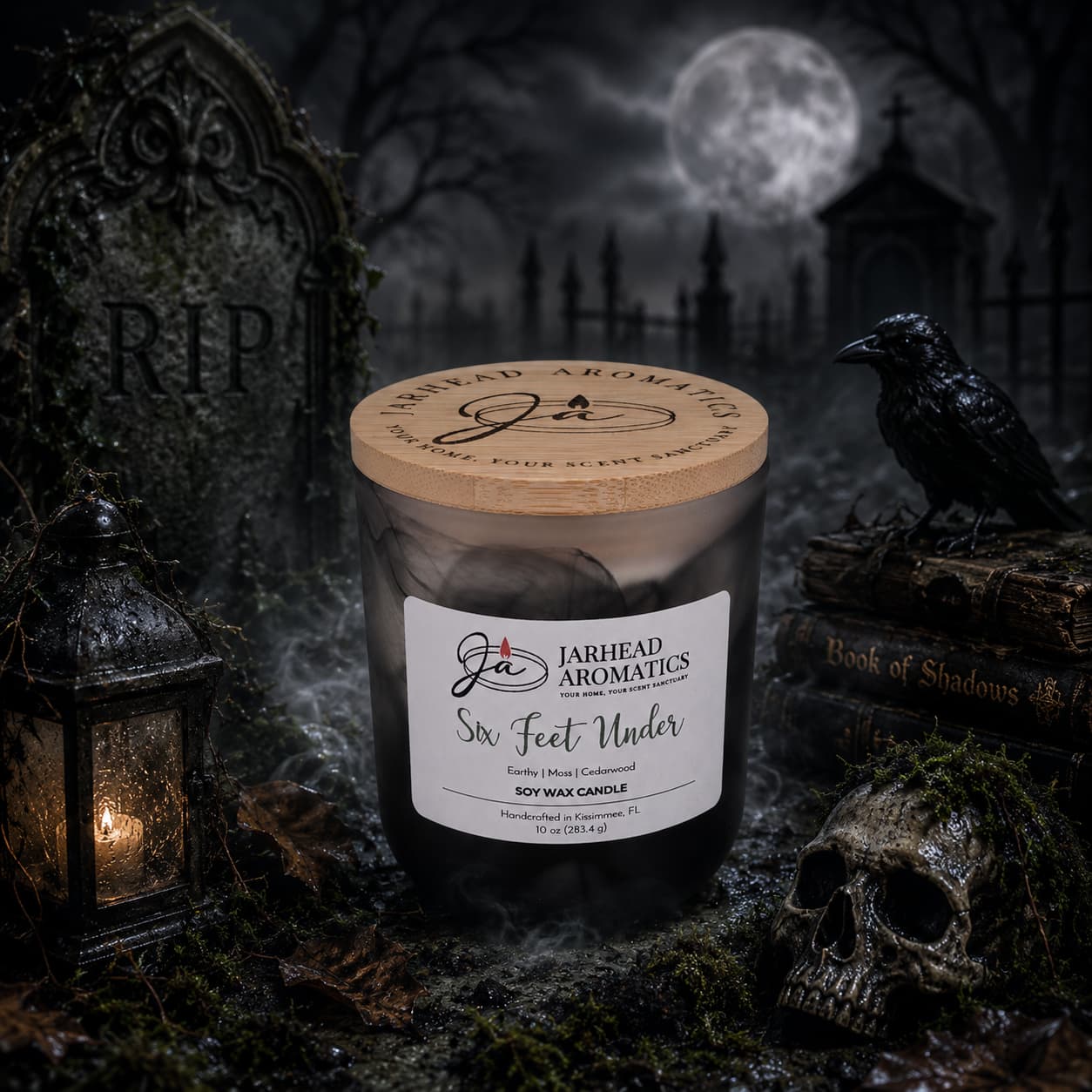 A spooky scene features the Six Feet Under Soy Wax Candle by Jarhead Aromatics, nestled in a graveyard among a skull, raven, tombstone, lantern, and Book of Shadows. The misty moonlit night enhances the eerie Halloween atmosphere as earthy moss, damp soil, and cedarwood scents evoke the essence of a haunted cemetery.