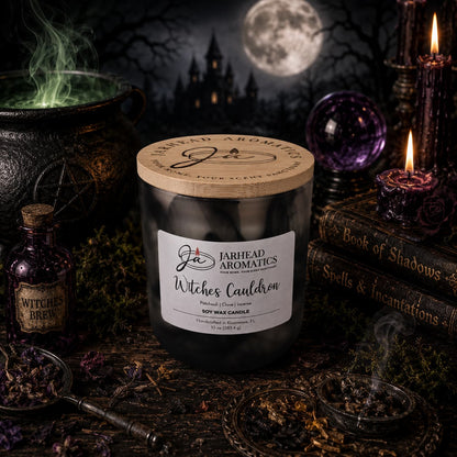 A Jarhead Aromatics Witches Cauldron Soy Wax Candle, scented with orange blossom, patchouli, clove, and incense, sits on a dark table surrounded by potion bottles, a pentagram, spell books, and flickering candles. Beside this enchanting Halloween candle glows a misty green potion, while a full moon illuminates a gothic castle in the background.