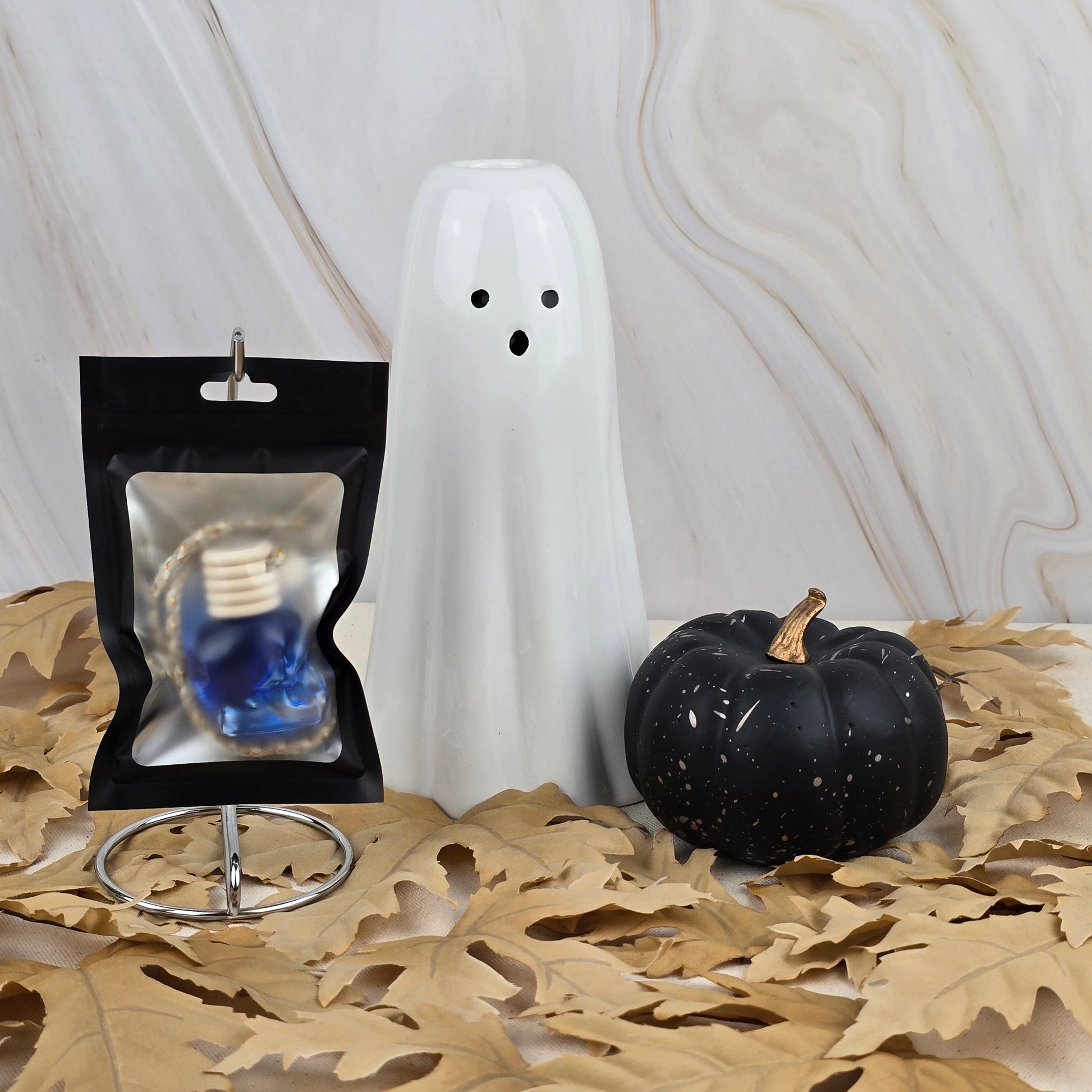 The Bewitching Hour Car Diffuser from Jarhead Aromatics Halloween Collection, shown with haunting decor on dried leaves against a marble backdrop.