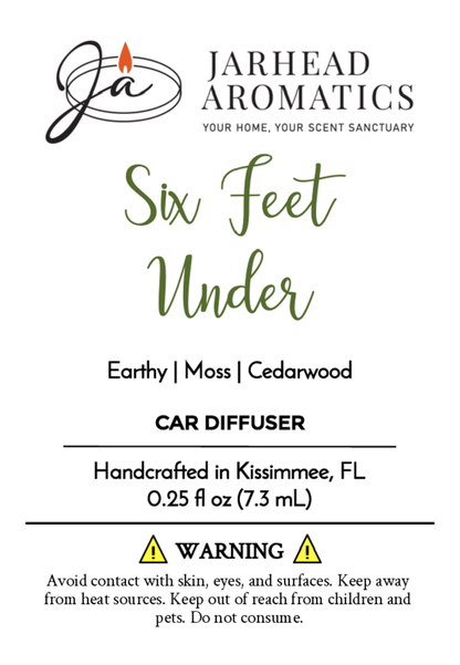 Label for Jarhead Aromatics Six Feet Under - Car Diffuser (Halloween Collection), featuring earthy moss and cedarwood notes, woody undertone, product details, warnings, and a logo with stylized JA and candle flame.