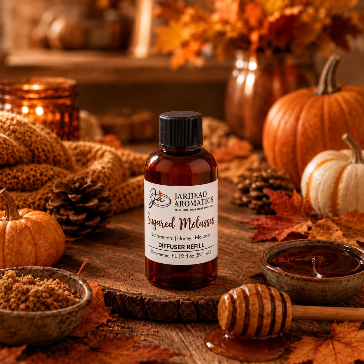A bottle labeled Sugared Molasses Diffuser Refill from Jarhead Aromatics sits on a rustic table surrounded by autumn leaves, pumpkins, honey, brown sugar, and cozy knit fabric in a warm, fall-themed setting. The inviting scene captures the essence of an autumn home fragrance, blending notes of buttercream, honey, and dark molasses with seasonal charm.