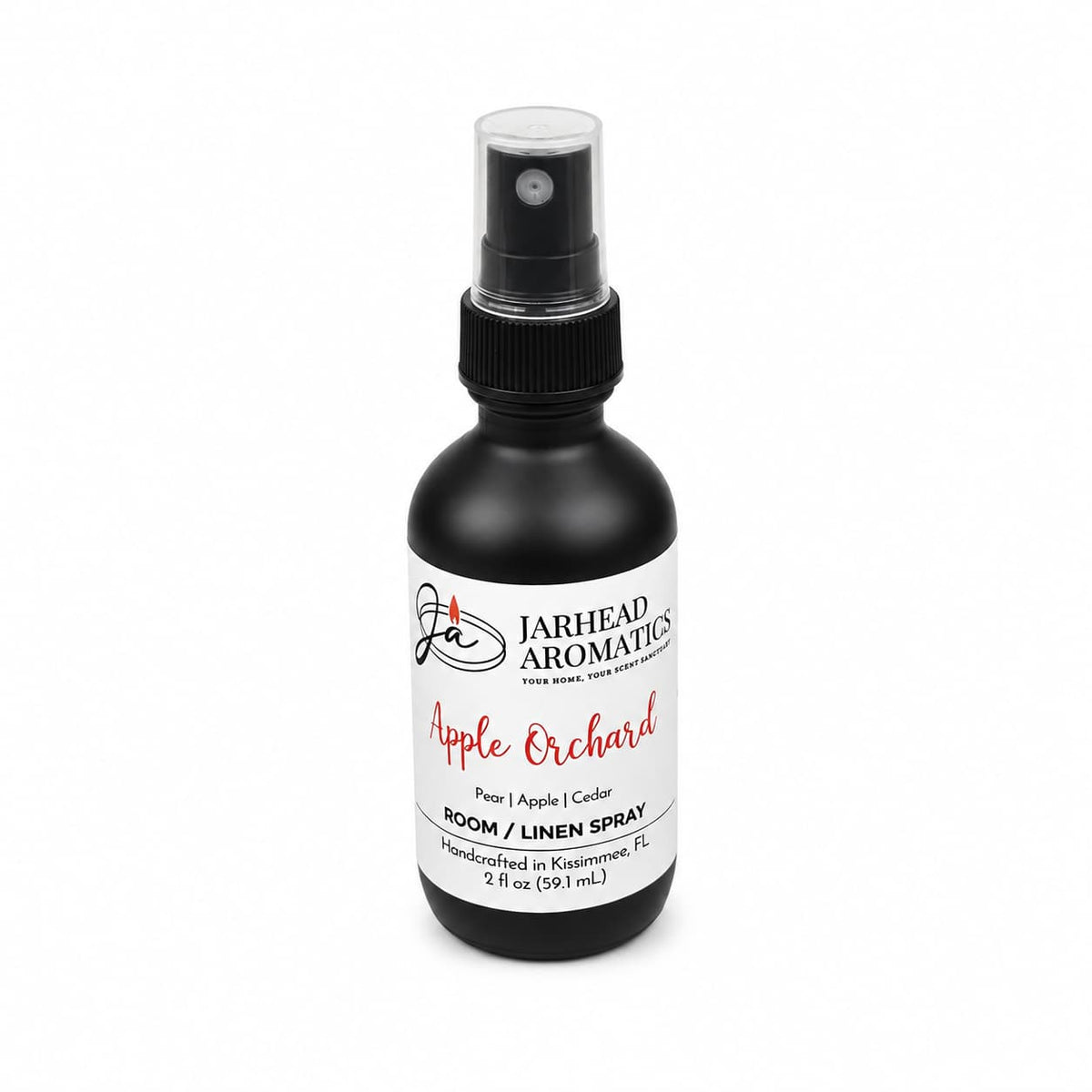 A 2 fl oz (59 mL) black spray bottle of Jarhead Aromatics’ Apple Orchard Room & Linen Spray | Crisp Apple, Pear & Cedarwood, this handcrafted home fragrance from Kissimmee, FL features notes of pear, apple, and cedarwood.