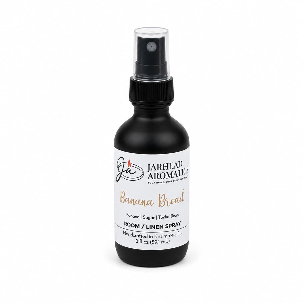 Experience the inviting scent of Jarhead Aromatics Banana Bread Room & Linen Spray, expertly handcrafted in Kissimmee, FL. This black spray bottle features a comforting gourmand fragrance with notes of banana, walnut, and warm vanilla. Elevate your space with every spritz and enjoy a cozy home ambiance. 2 fl oz (59 mL).