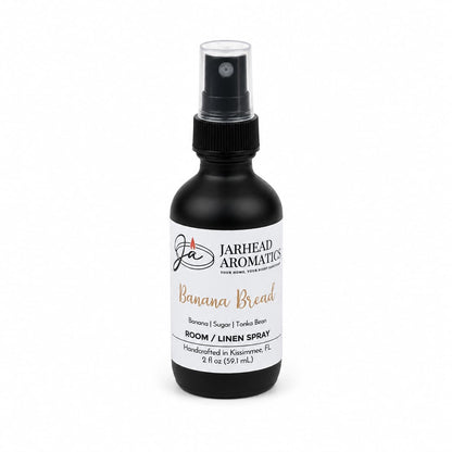 Experience the inviting scent of Jarhead Aromatics Banana Bread Room & Linen Spray, expertly handcrafted in Kissimmee, FL. This black spray bottle features a comforting gourmand fragrance with notes of banana, walnut, and warm vanilla. Elevate your space with every spritz and enjoy a cozy home ambiance. 2 fl oz (59 mL).