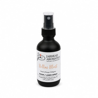 A sleek black spray bottle labeled Jarhead Aromatics Bellini Blast Room & Linen Spray delivers a vibrant tropical fragrance featuring peach, mango, and tangerine notes. Handcrafted in Kissimmee, FL, this 2 fl oz bottle is ideal for refreshing any room or linens.