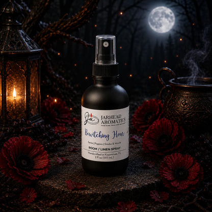 A bottle of Jarhead Aromatics Bewitching Hour Room & Linen Spray | Exotic Spices, Dark Florals & Smoky Woods rests among red flowers, a lantern, and a cauldron. In the background, a full moon glows behind shadowy trees, setting a mystical nighttime scene. This enchanting home fragrance from Jarhead Aromatics captures the essence of the night with its blend of exotic spices, dark florals, and smoky woods.