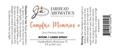 White label for Jarhead Aromatics Campfire Memories Room & Linen Spray | Maple, Clove & Smoky Embers, featuring directions, ingredients (maple, clove, smoky embers), warning, barcode, and company logo with a lit candle. Handcrafted in Kissimmee, FL. 2 fl oz spray for home fragrance and linens.