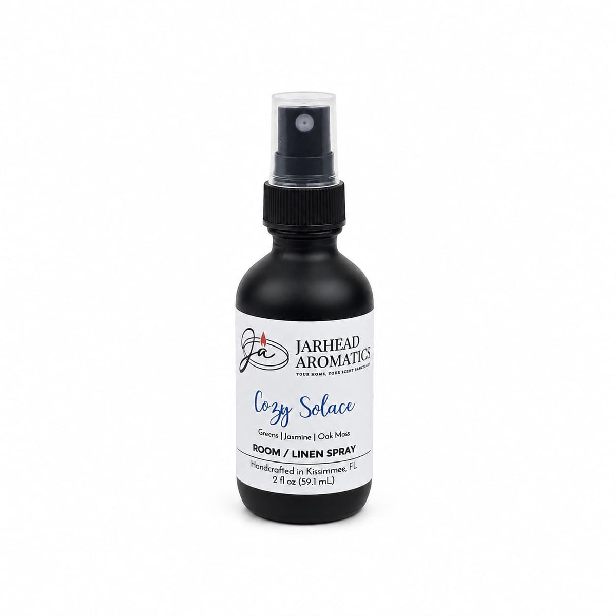 A black spray bottle labeled “Jarhead Aromatics Cozy Solace Room & Linen Spray” is displayed on a white background. This luxurious 2 fl oz (59.1 ml) room and linen spray features fresh greens, jasmine, and oak moss scents and is handcrafted in Kissimmee, FL.