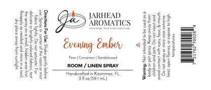 The label for Jarhead Aromatics Evening Ember Room & Linen Spray—featuring a blend of plum, sandalwood, and soft smoke—displays directions, warnings, ingredients, and product details. Handcrafted in Kissimmee, FL, this 2 fl oz home fragrance comes with a barcode on the right.
