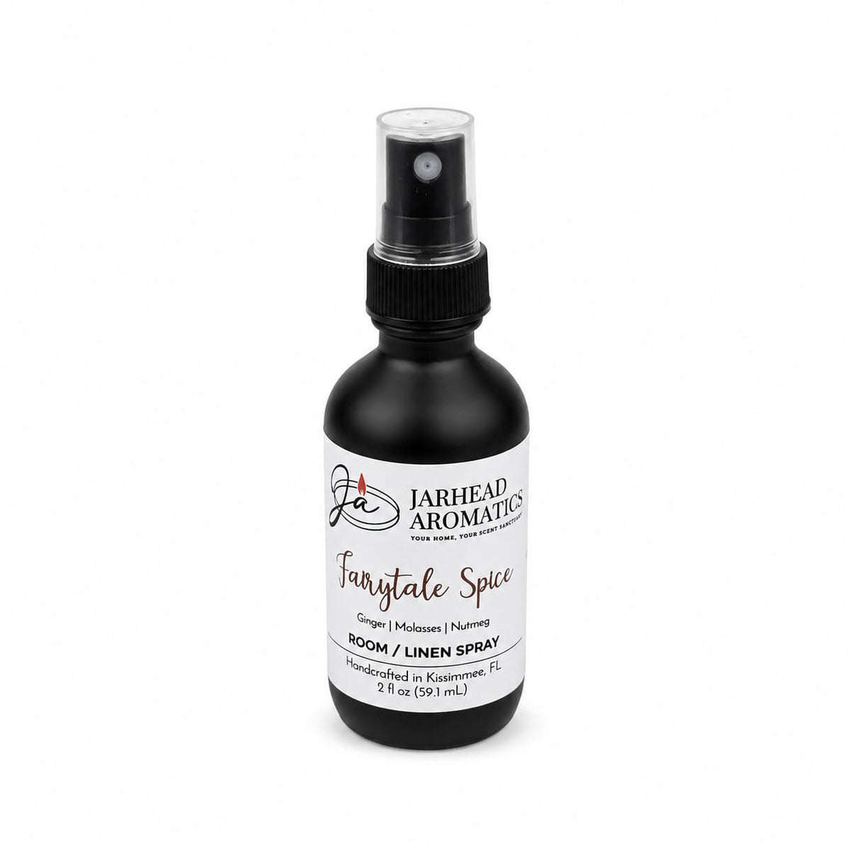 A black spray bottle labeled “Jarhead Aromatics Fairytale Spice Room & Linen Spray | Gingerbread, Molasses & Warm Spice” offers a bakery-inspired home fragrance with notes of gingerbread, molasses, and warm spices, reminiscent of a gingerbread house. The bottle contains 2 fl oz (59 mL).