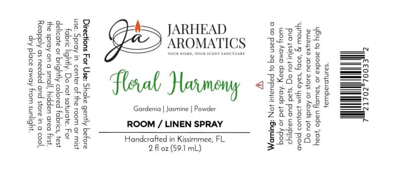 Here’s your revised sentence using the provided product data: A label for Jarhead Aromatics Floral Harmony Room & Linen Spray | Gardenia, Jasmine & Tuberose, crafted for floral fragrance enthusiasts. Enjoy the elegant aroma of gardenia, jasmine, and tuberose with a soft powdery scent in every spritz—ideal as a gardenia linen spray or to refresh any space. Directions and warnings are printed on the sides. The logo displays a candle flame above the Jarhead Aromatics brand name.