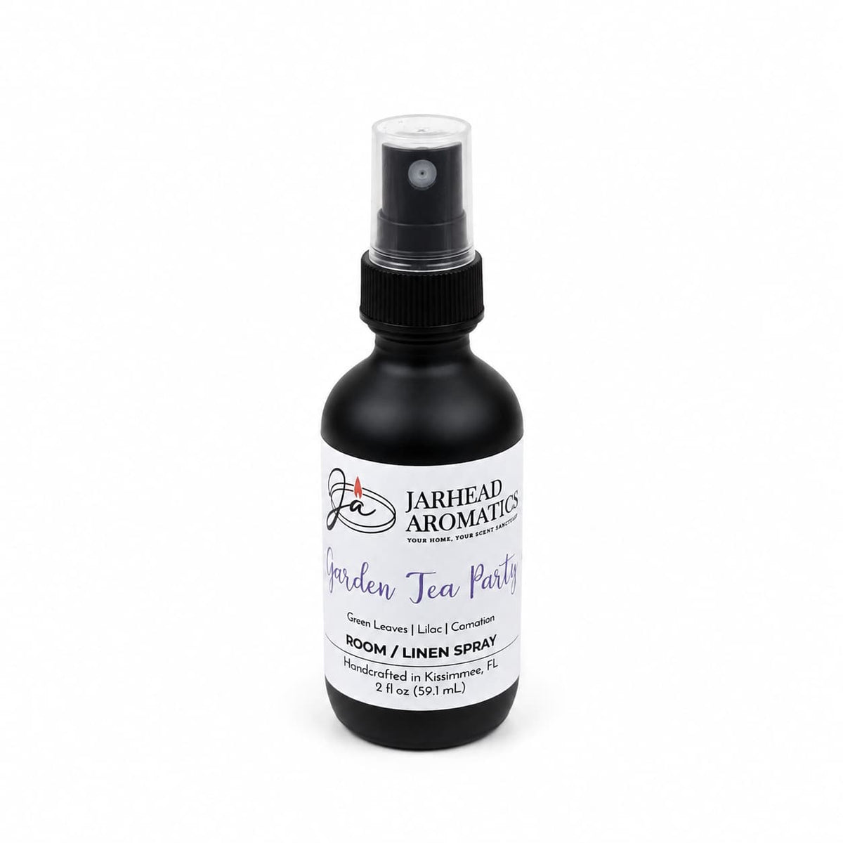 A black spray bottle labeled Jarhead Aromatics Garden Tea Party Room & Linen Spray, 2 fl oz, features a garden-inspired fragrance with notes of Rose, Lilac, and Jasmine for a delightful floral home scent experience.