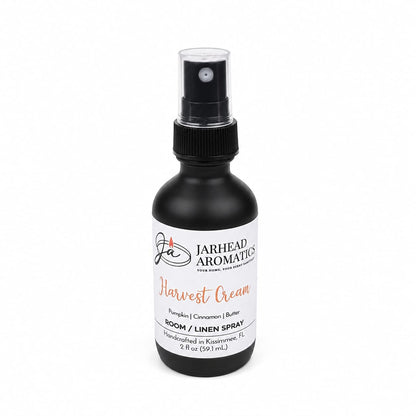A black spray bottle labeled Jarhead Aromatics Harvest Cream Room & Linen Spray offers a luscious blend of pumpkin spice, brown sugar, and vanilla cream. Handcrafted in Kissimmee, FL, this gourmand home fragrance comes in a 2 fl oz size—perfect for refreshing any space—and is shown on a white background.