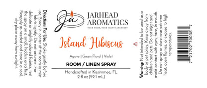 Label for Jarhead Aromatics Island Hibiscus Room & Linen Spray | Honeydew, Lime & Tropical Florals. Enjoy the uplifting tropical scent of honeydew, lime, and exotic florals—perfect to refresh any room or as a linen spray. Directions, ingredients (including agave, green floral notes, violet), warnings, and product information are included. Features a candle flame logo and a barcode on the right.