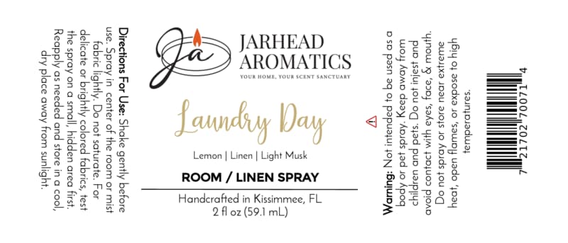 White label for Jarhead Aromatics Laundry Day Room & Linen Spray | Fresh Linen, Lemon & Clean Musk, featuring black and gold text with a flame logo at the top left. Includes directions, warning, ingredients (Fresh Linen, Lemon & Clean Musk), barcode, and handcrafted note. This clean home fragrance revitalizes any space with the fresh scent of linen enhanced by crisp lemon and clean musk notes.