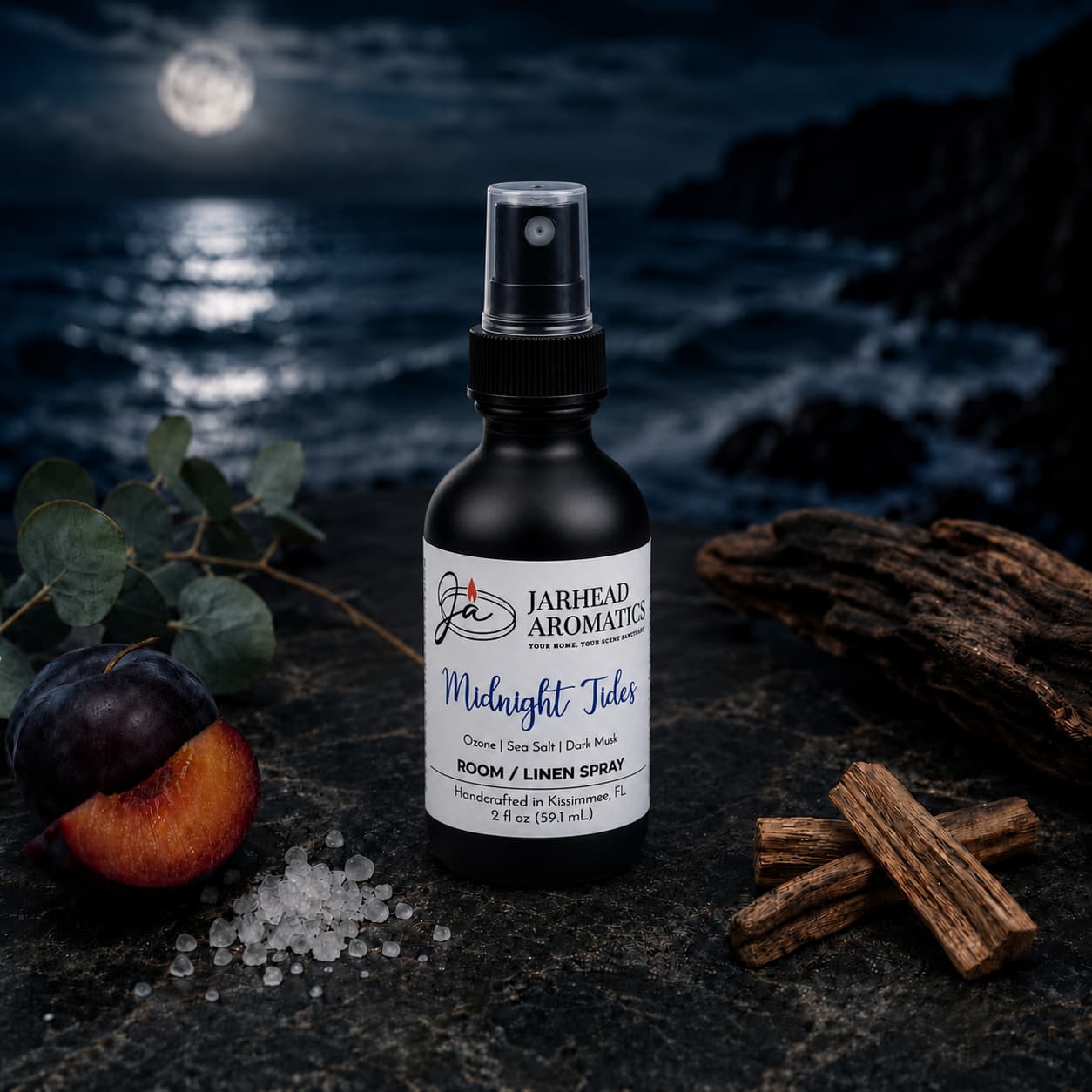 A bottle of Jarhead Aromatics’ Midnight Tides Room & Linen Spray—blending sea salt, sandalwood, and dark musk—rests atop a dark rock, its coastal scent capturing the freshness of a moonlit ocean beneath a cloudy night sky.