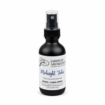A 2 fl oz black spray bottle from Jarhead Aromatics, labeled “Midnight Tides Room & Linen Spray | Sea Salt, Sandalwood & Dark Musk,” featuring a handcrafted marine-inspired fragrance with notes of sea salt, sandalwood, and dark musk. Made in Kissimmee, FL.