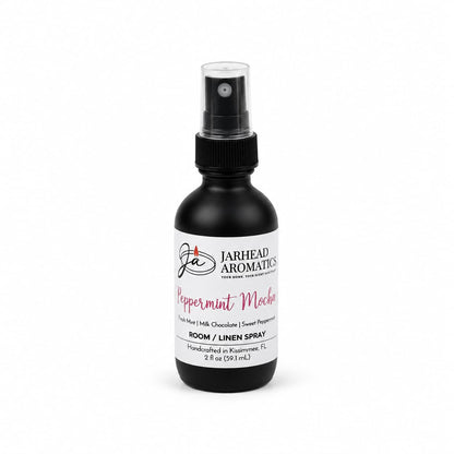 A black bottle of Jarhead Aromatics Peppermint Mocha Room & Linen Spray | Chocolate Mint & Vanilla with a black pump, featuring a white label that lists scent notes of fresh mint, milk chocolate, and sweet peppermint.