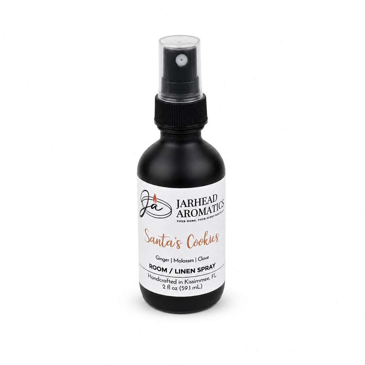 A small black spray bottle of Santa’s Cookies Room & Linen Spray, featuring a white label with notes of ginger, molasses, and clove.