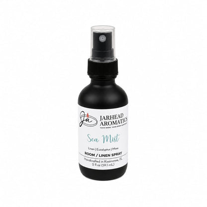A black spray bottle labeled Jarhead Aromatics Sea Mist Room & Linen Spray in the Fresh Linen, Sea Salt & Eucalyptus scent (2 oz) evokes a spa-inspired experience—perfect for adding a touch of coastal fragrance to your home. Displayed on a white background.