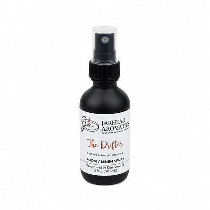 Introducing The Drifter Room & Linen Spray by Jarhead Aromatics, a 2 fl oz (59 mL) black spray bottle that infuses your space with a sophisticated blend of leather, tuberose, and smoky agarwood. This western-inspired fragrance adds rugged elegance and refreshing character to any room or linen.