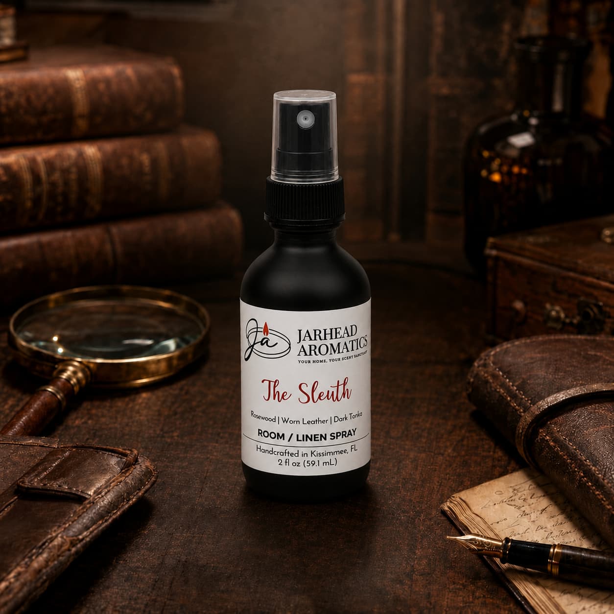 A bottle of Jarhead Aromatics The Sleuth Room & Linen Spray | Leather, Rosewood & Sandalwood rests on a table surrounded by vintage books, a magnifying glass, a pen, and a leather notebook in a cozy, warm-toned setting—an inviting atmosphere elevated by the refined blend of leather, rosewood, and sandalwood that characterizes this exquisite home fragrance.