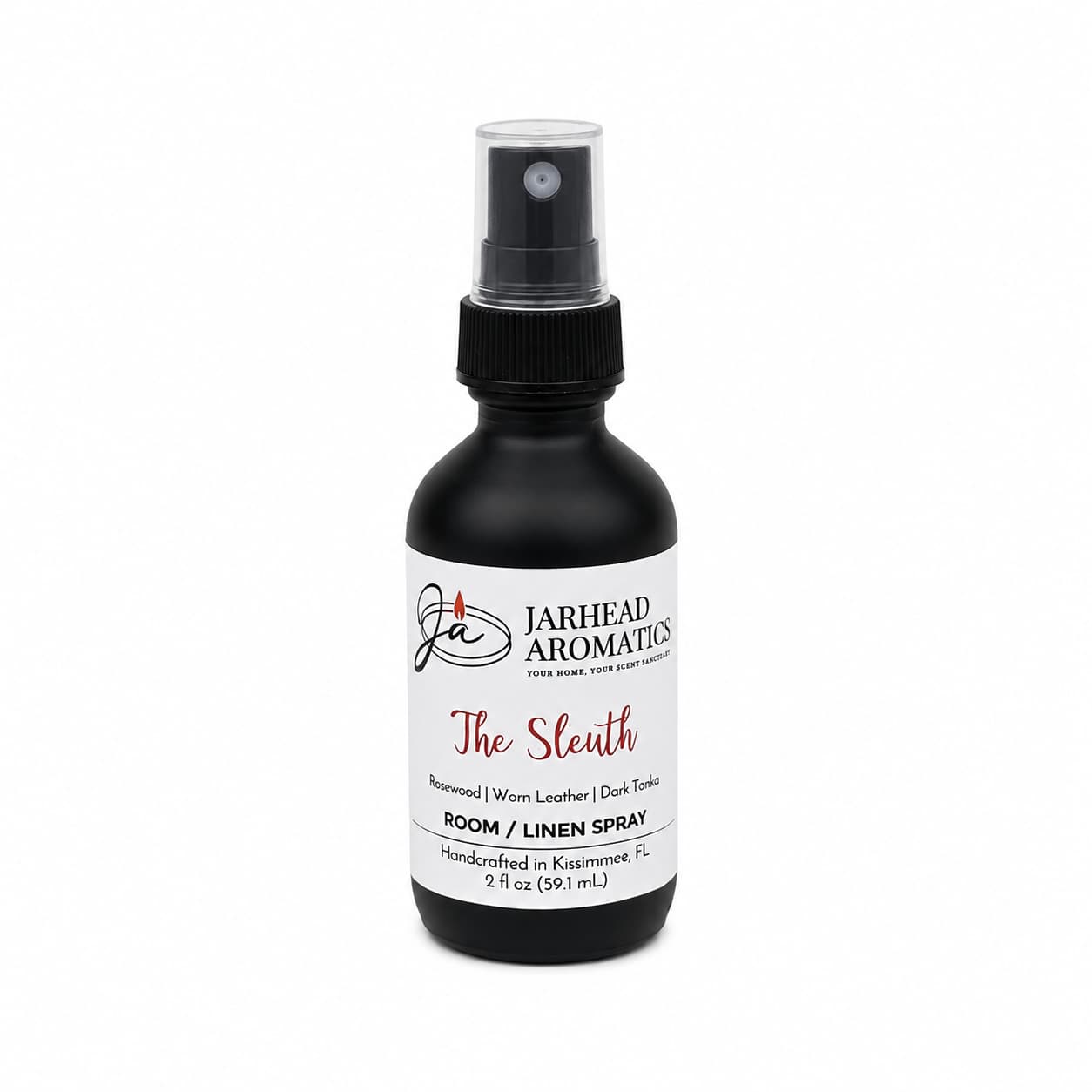 A black spray bottle labeled “The Sleuth Room & Linen Spray | Leather, Rosewood & Sandalwood” by Jarhead Aromatics features notes of rosewood, worn leather, sandalwood, and dark tonic. This handcrafted 2 fl oz home fragrance is made in Kissimmee, FL—perfect for refreshing any room or linens.