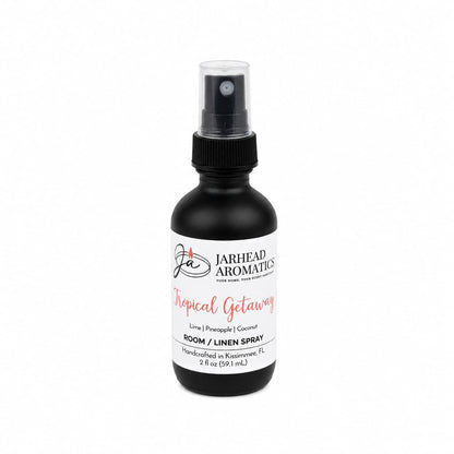 A black spray bottle labeled Jarhead Aromatics Tropical Getaway Room & Linen Spray features a vibrant home fragrance with coconut, mango, and pineapple scents. Handcrafted in Kissimmee, FL, this 2 fl oz tropical spray is ideal for linens or any space seeking a breezy getaway aroma.