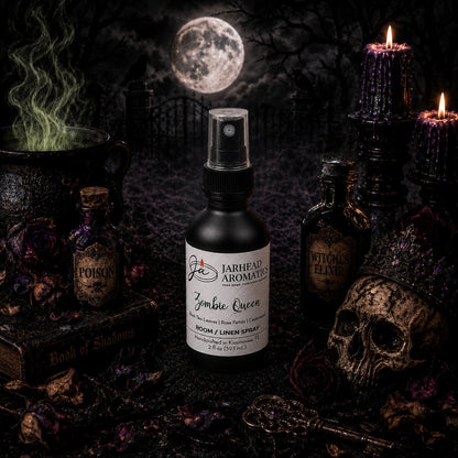 Amidst dried roses, flickering candles, potion bottles, a skull, and a mysterious Book of Shadows, the Zombie Queen Room & Linen Spray | Black Tea, Rose Petals & Cedarwood by Jarhead Aromatics sits at the heart of a gothic tableau. Set against the backdrop of a shadowy graveyard bathed in full moonlight and creeping fog, this haunting spray fills the air with its dark floral fragrance—notes of black tea, rose petals, and cedarwood—perfectly enhancing the eerie ambiance and elevating any gothic home with