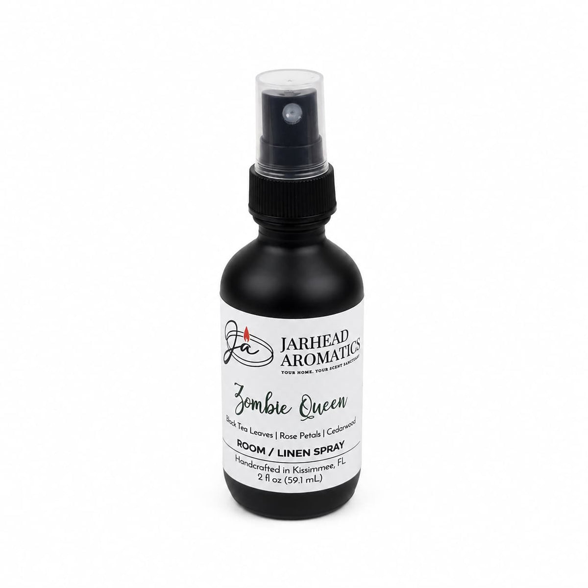A black spray bottle labeled Zombie Queen Room & Linen Spray by Jarhead Aromatics, featuring notes of black tea, rose petals, and cedarwood. This elegant gothic home fragrance comes in a 2 fl oz bottle with a dark floral scent, complete with a white label and black text—perfect for adding an air of mystery to any room or linen.