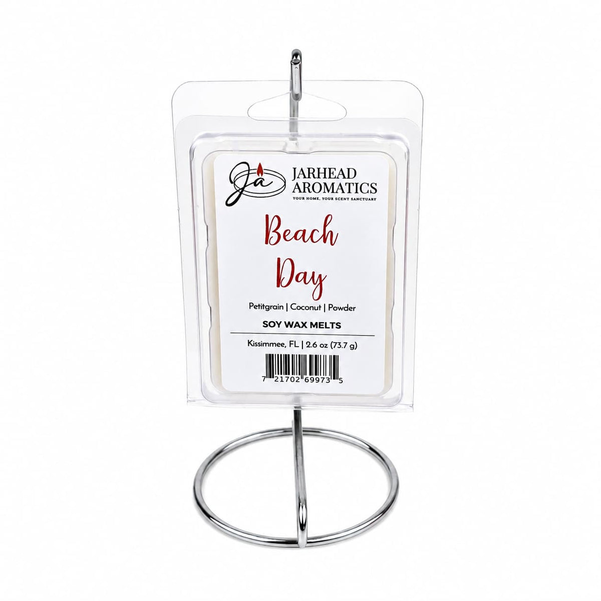 A pack of Jarhead Aromatics Beach Day Soy Wax Melt | Citrus, Coconut & Coastal Musk is displayed upright on a silver metal stand, with the label highlighting its fresh blend of citrus, coconut, and coastal musk scents. This highly fragrant soy wax melt delivers a long-lasting aroma that perfectly captures the essence of a relaxing day at the beach.